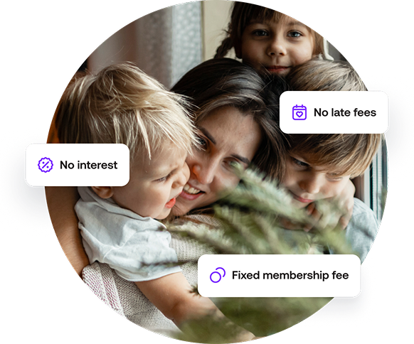 Photo of a woman and 3 kids looking happy by a Christmas tree